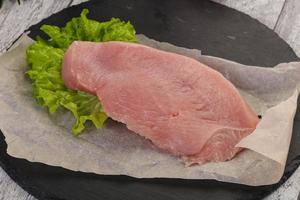 Raw Turkey steak served rosemary photo