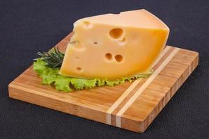 queso maasdam en el tablero hojas de ensalada servidas foto