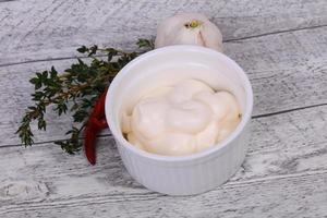 Mayonnaise sauce in the white bowl served thyme and garlic photo