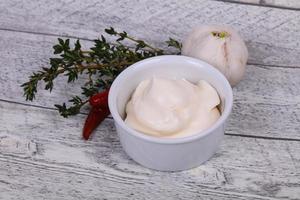 Mayonnaise sauce in the white bowl served thyme and garlic photo