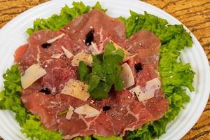 Beef carpaccio with parmesan cheese photo