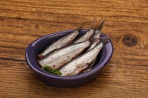 Anchovies in the bowl served basil leaves photo