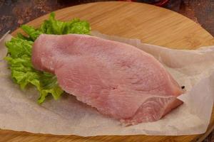 Raw Turkey steak served rosemary photo