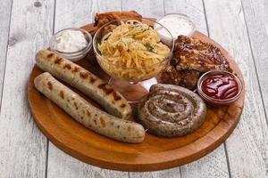 Meat plate with grilled sausages, ribs and chicken wings photo