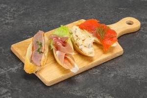 Tapas - bruschetta with prosciutto, salmon, duck and gorgonzola photo