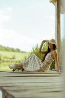 Young woman relaxing on the wooden pier at the calm lake photo