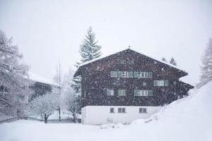 casa de montaña en tormenta de nieve foto