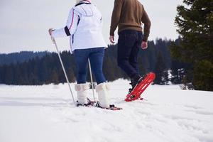 couple having fun and walking in snow shoes photo