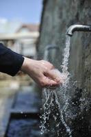 fresh mountain water falling on hands photo