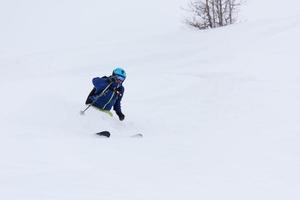 freeride skier skiing in deep powder snow photo