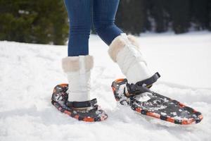 pareja divirtiéndose y caminando con raquetas de nieve foto