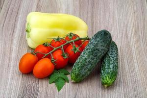 Cucumbers and tomatoes on the branch with yellow pepper photo