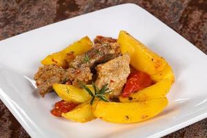 Baked pork meat with potao and tomato photo