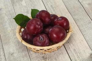 Plum heap in the wooden basket photo