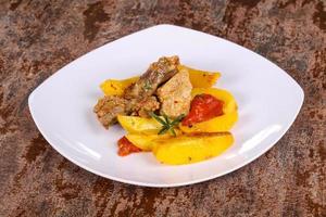 Baked pork meat with potao and tomato photo