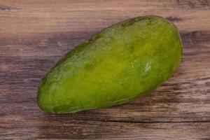 Green tasty mango over wooden background photo