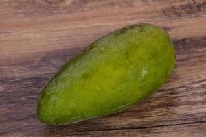 Green tasty mango over wooden background photo