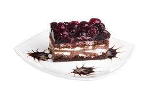 pastel de chocolate con cereza en la parte superior sobre un fondo blanco foto