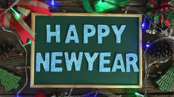 Santa's hand laid wooden letters for the word Happy New Year on the blackboard. video