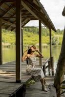 Young woman relaxing on the wooden pier at the calm lake photo