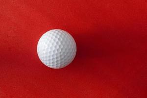 Golf ball on a red background photo