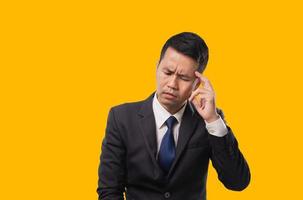 Asian businessman touching his head with his hand Expressing stressful gestures, depression, unhappy, and headaches. Business concept. photo