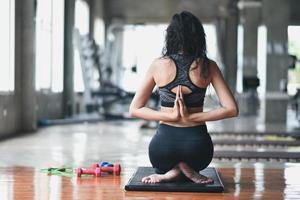 sport asian woman practicing yoga lesson, breathing, meditating, doing Ardha Padmasana exercise, working out in the gym photo