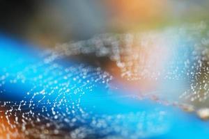 blurred abstract spiderweb natural with rain drop on the line against the sun orange blue photo