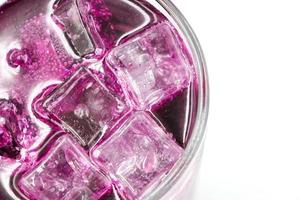 Grape sparkling water with Ice in glass over white background.