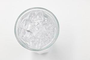 agua con gas de soda con hielo en vaso sobre fondo blanco. foto