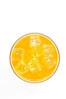Orange sparkling water with Ice in glass over white background.