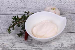 Mayonnaise sauce in the white bowl served thyme and garlic photo