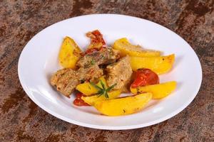 Baked pork meat with potao and tomato photo