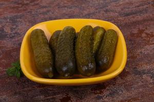 Pickled cucumbers heap in the bowl photo