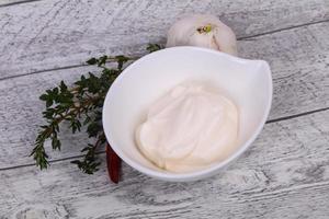 Mayonnaise sauce in the white bowl served thyme and garlic photo