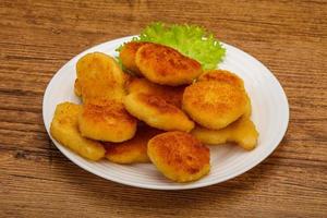 Fried chicken nuggets served salad leaves photo