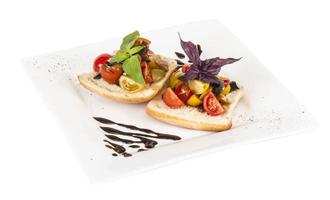 juicy tomatoes on fresh bread, pesto as topping photo