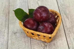 Plum heap in the wooden basket photo