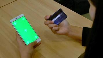 imagen de primer plano de un negocio de mano de mujer. use el teléfono con una pantalla verde en la oficina durante el almuerzo. video