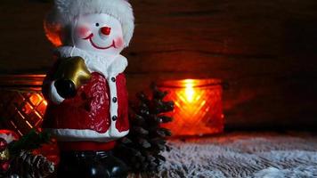 Christmas tree, Santa Claus toy and snowman in snow globe with Burning candles for new year or christmas holiday international on wooden background video