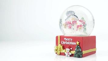 Close up of Christmas tree and snowman in snow globe on white background video