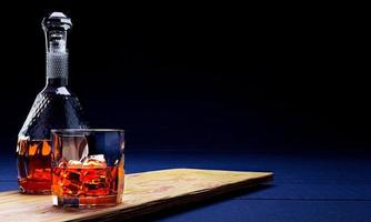 Brandy or whiskey in a clear glass with ice cubes. Alcoholic beverages placed on wooden coasters. Bar drink concept. 3D rendering. photo