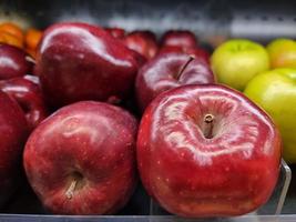 manzanas rojas en un estante en el supermercado foto