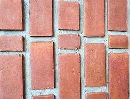 bloque de ladrillo cuadrado naranja en la pared de cemento con textura y fondo. Imagen de línea vertical de construcción de casas de interiores fuertes foto