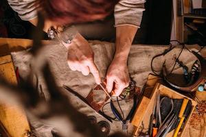 herramientas de trabajo de alambre de cobre hechas a mano sobre la mesa con accesorios. concepto de arte de personas de artesanía foto