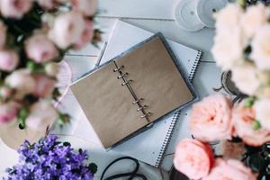 hermosas flores sobre la mesa con cuaderno vacío. foto