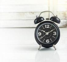 Alarm clock against wooden photo