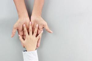 flat lay child small hand put on father hands-on gray background with love and care photo