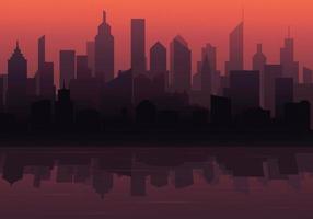 The silhouette of a big city with a beautiful sunset. The city is reflecting in the water. Urban landscape.Vector illustration