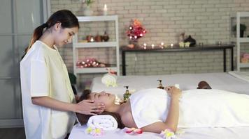 junge asiatische frau entspannende gesichts-spa-massage, wellness, schönheits- und entspannungskonzept video